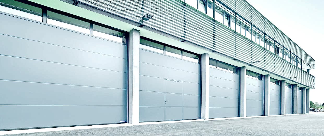Row of insulated sectional doors along an industrial elevation