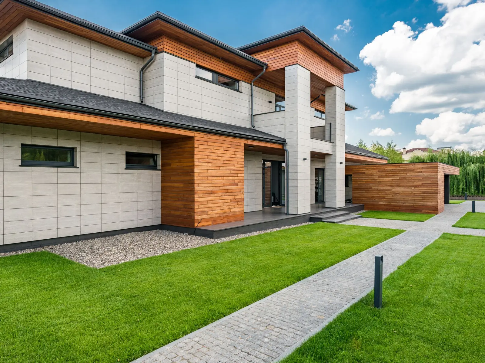 Contemporary two-storey villa with a panel-clad facade and timber detailing